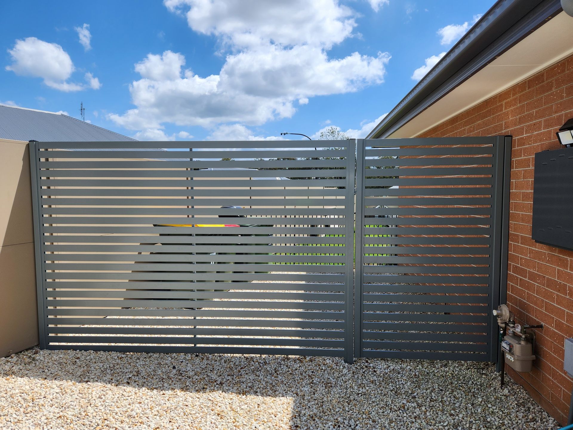 A black gate is sitting in front of a brick building.