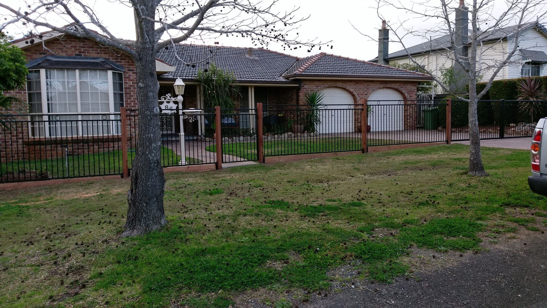 A brick house with a wrought iron fence in front of it