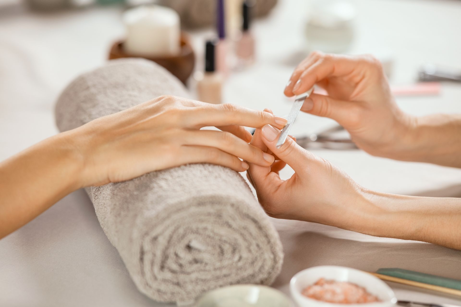 Eine Frau lässt sich in einem Nagelstudio die Nägel machen.
