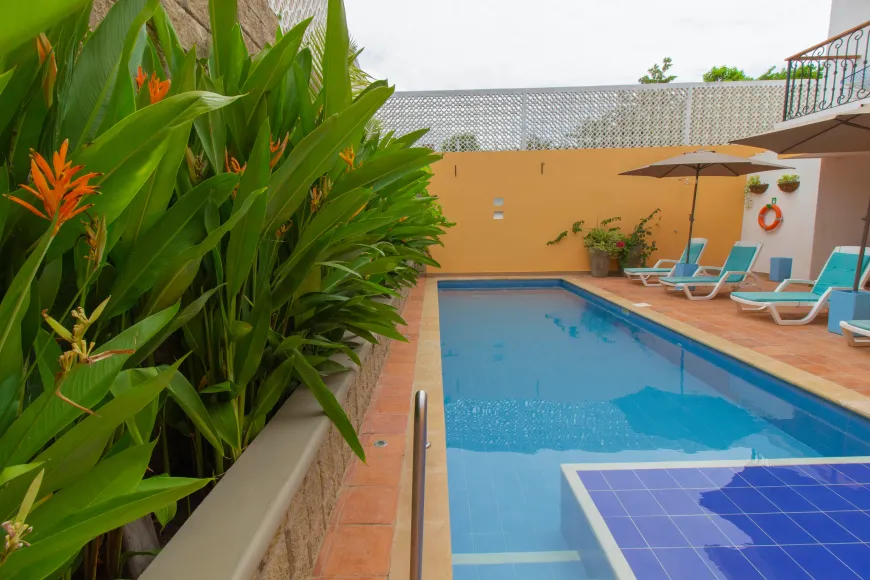 Una gran piscina rodeada de plantas y sillas.