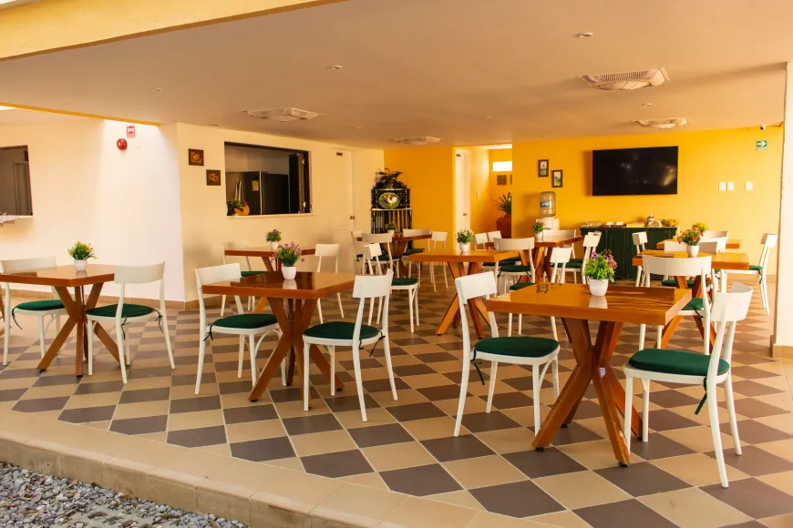 Un restaurante con mesas y sillas y suelo de cuadros.