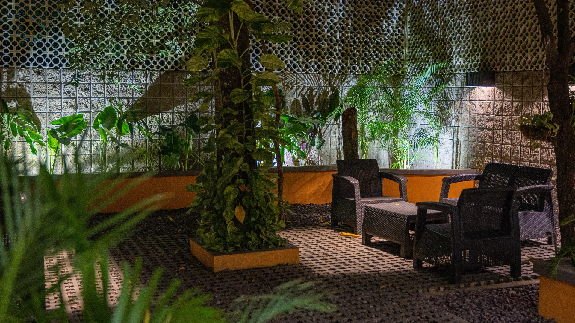 Un área de patio con mesa y sillas por la noche.