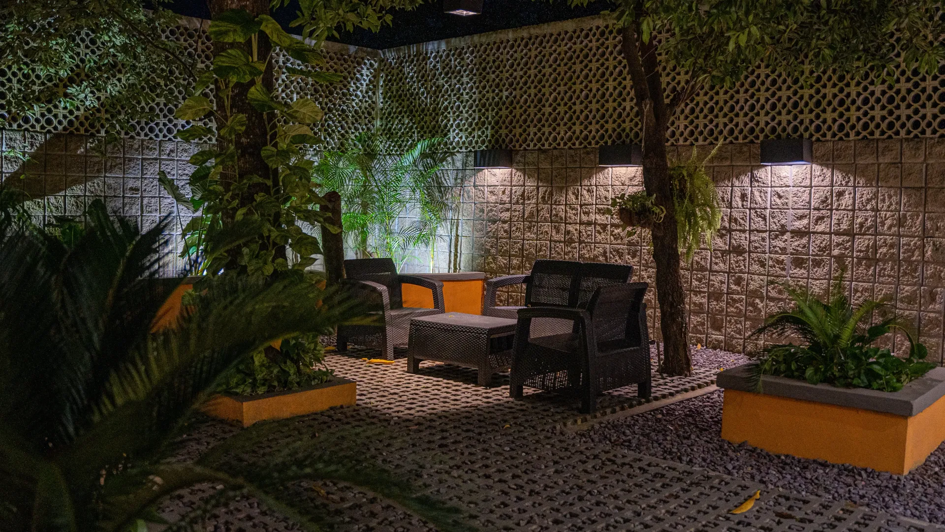 Un área de patio con mesa y sillas por la noche.
