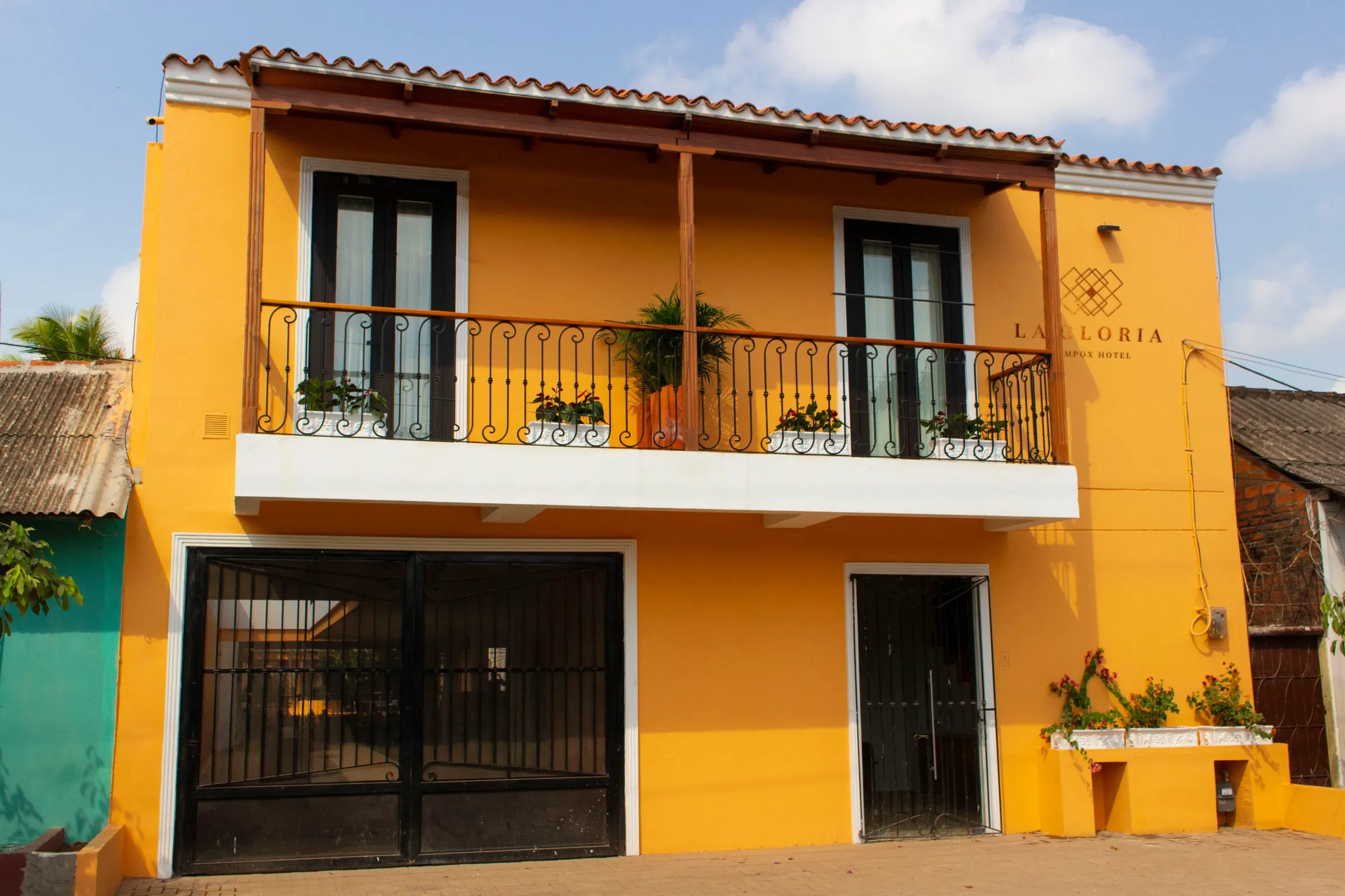 Exterior del  Hotel La gloria en Mompox Colombia pintado en color amarillo con balcón y valla