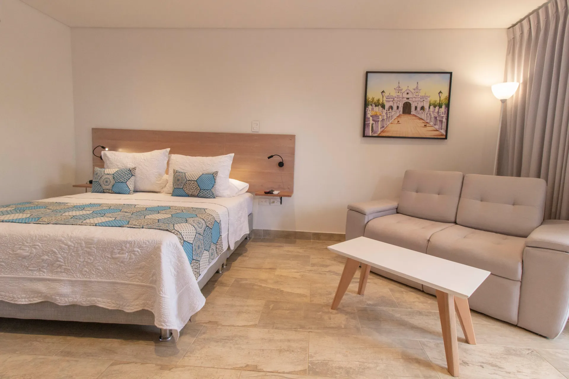 Una habitacióndel hotel La gloria en Mompox Colombia  hotel con una cama, un sofá, una mesa y un cuadro en la pared.
