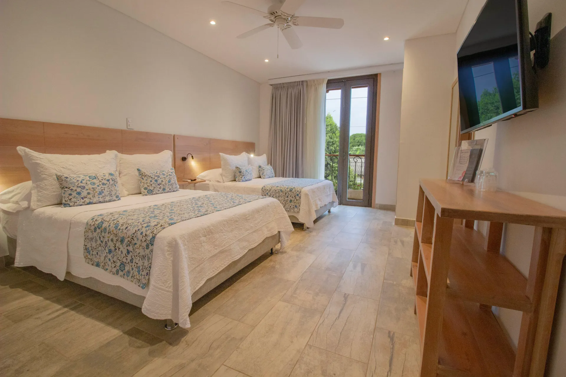 Una habitación de hotel con dos camas y un televisor de pantalla plana.