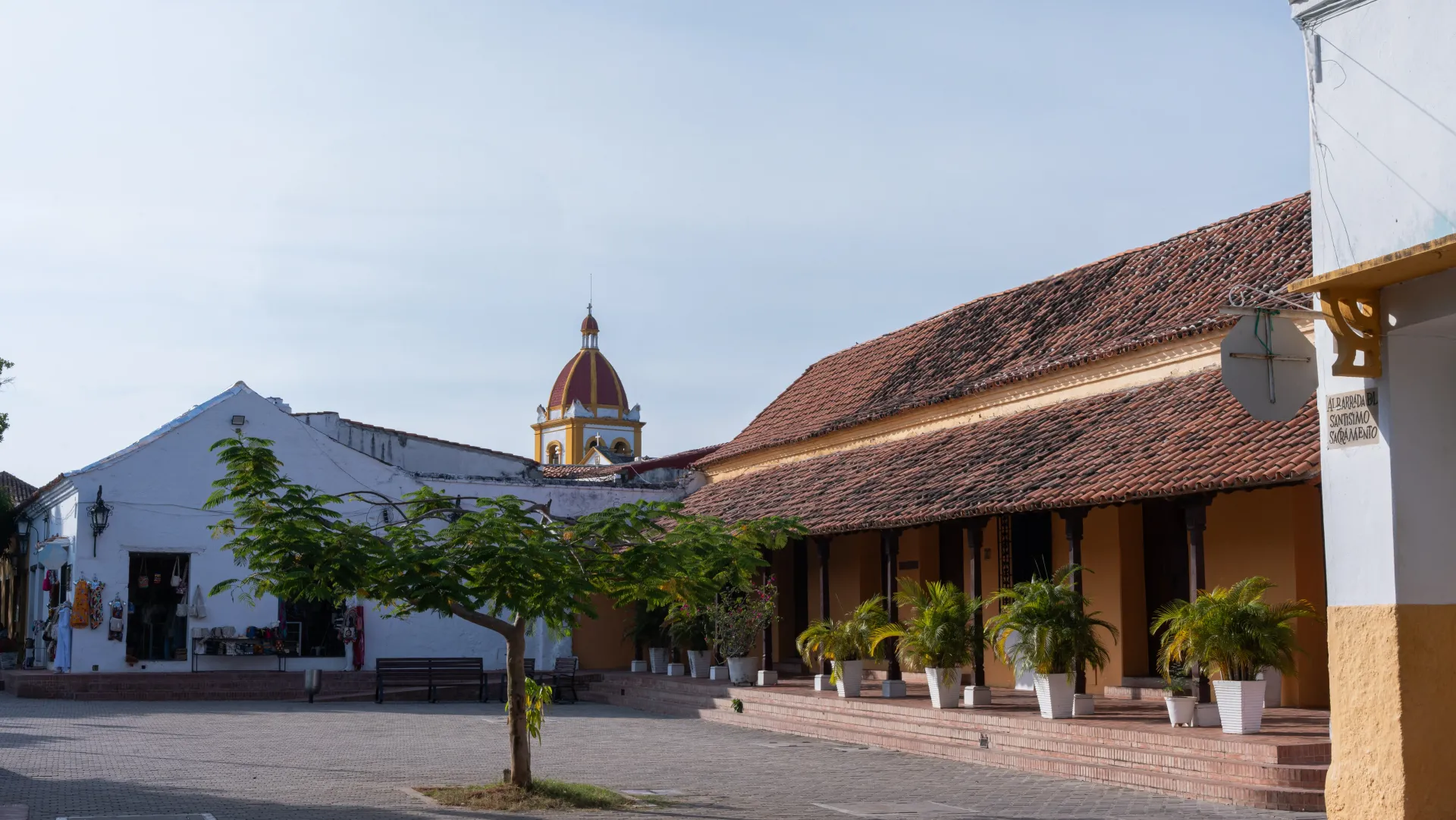 Una hilera de edificios con una torre de reloj al fondo.