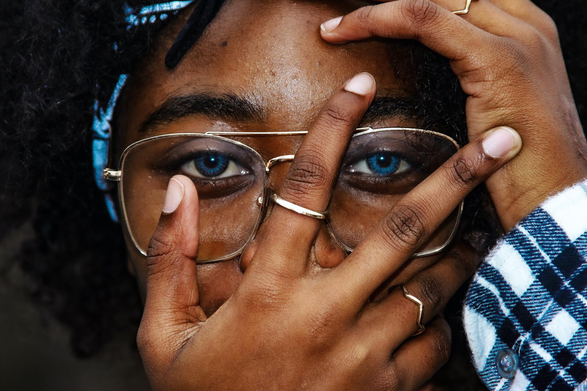 eyes in glasses being covered by fingers