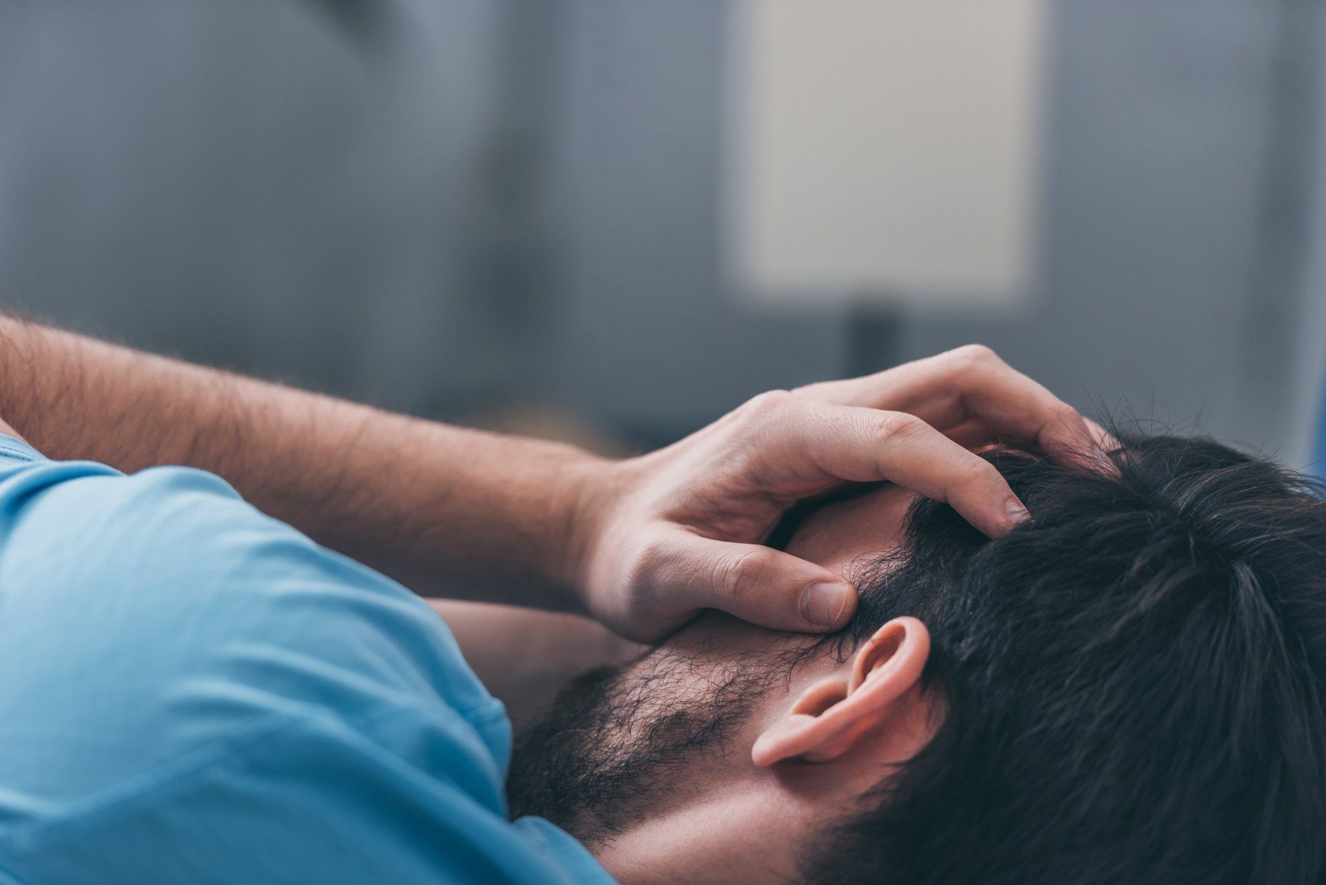PTSS Voorbij | Effectief herstel van PTSS en trauma | Selectieve focus van een rouwende man die met zijn handen zijn gezicht bedekkend ligt te huilen op bed