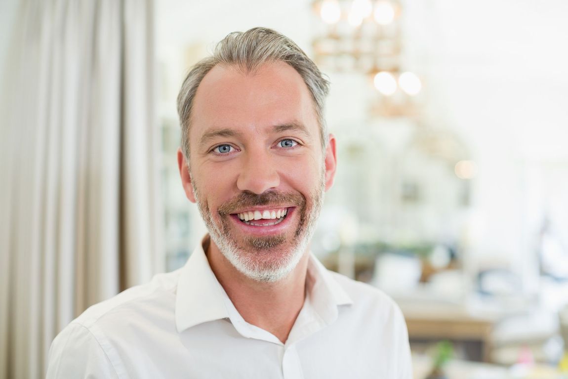 PTSS Voorbij-Integraal en holistisch herstel van PTSS en Trauma-Johan Reinhoudt-Portret van lachende man thuis in de woonkamer