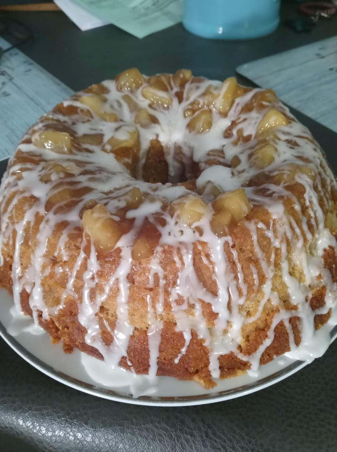 A bundt cake on a plate with icing on it