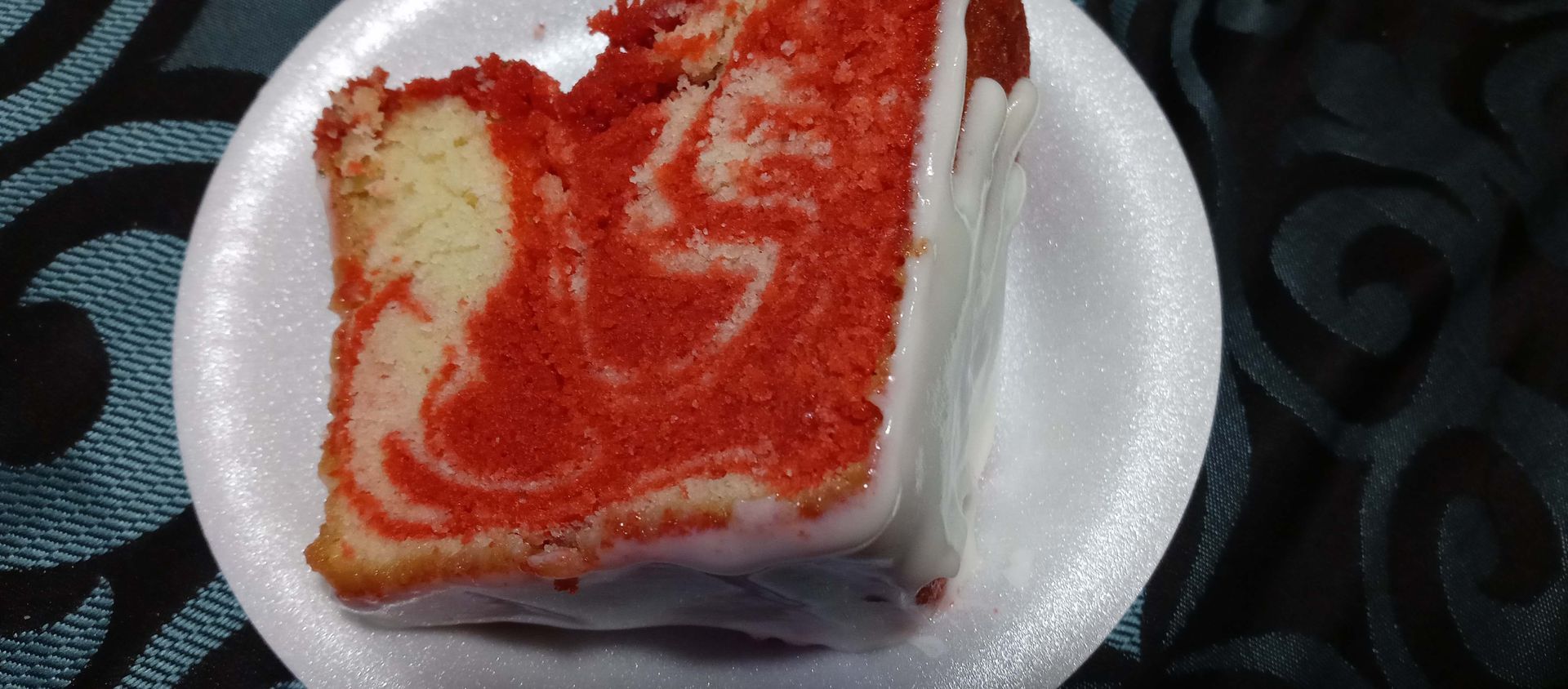 A slice of red velvet cake is on a white plate.