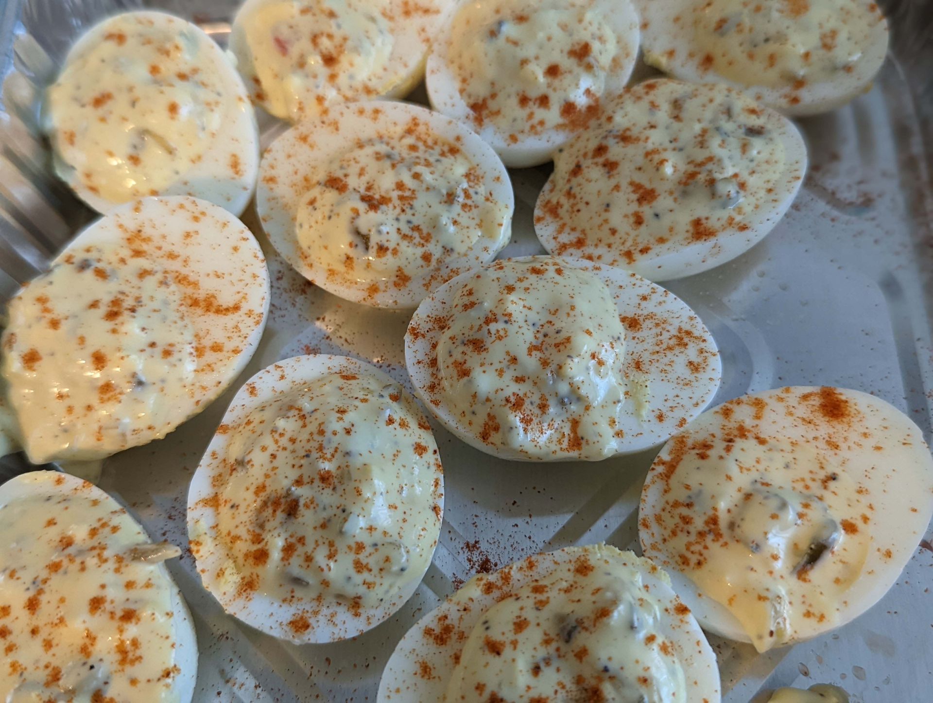 A bunch of stuffed eggs are sitting on top of a pan.