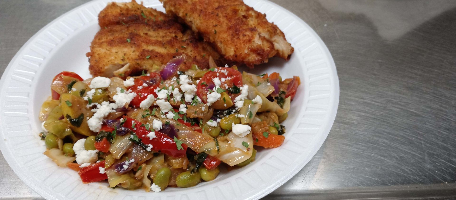 A plate of food with fried chicken and vegetables on a table.