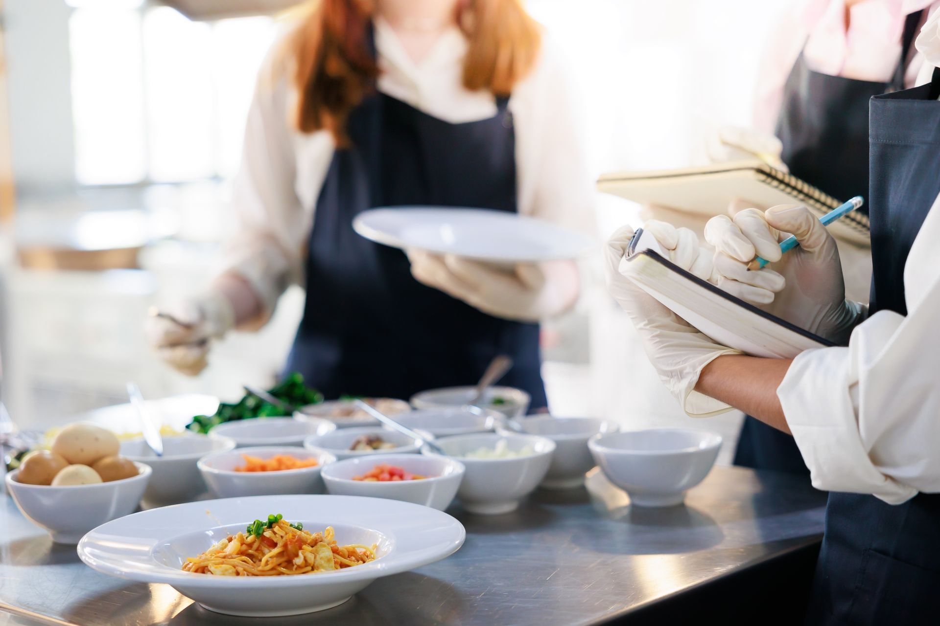 take note on book. Cooking class. culinary classroom. group of happy young woman multi-ethnic students are focusing on cooking lessons in a cooking school.