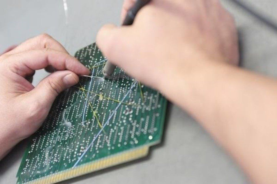 tecnico mentre interviene su una scheda elettronica