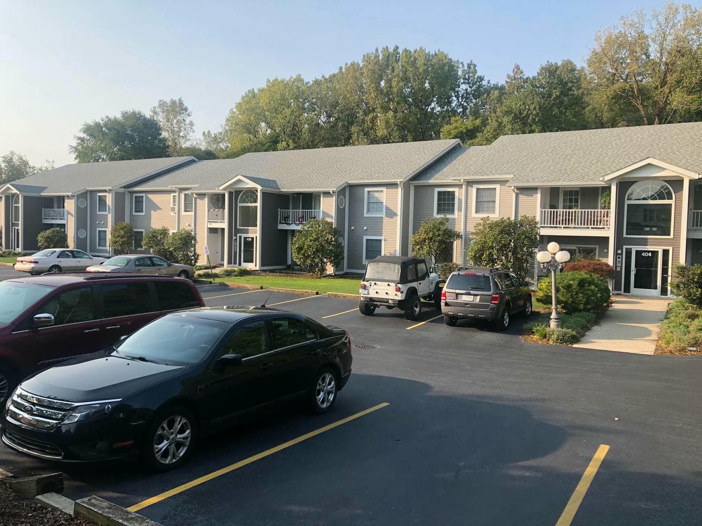 A row of apartments with cars parked in front of them