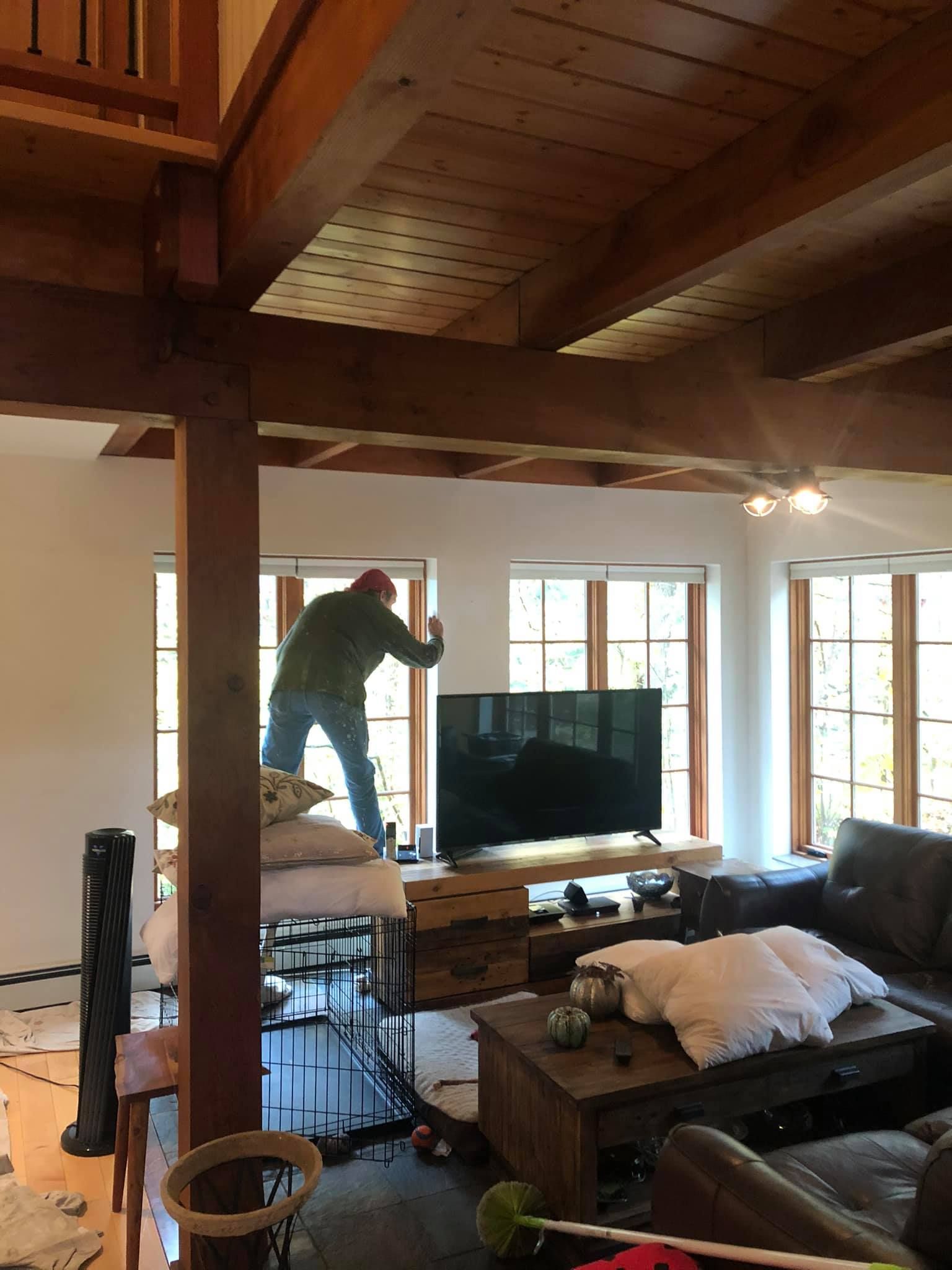 A man is standing in a living room in front of a television.