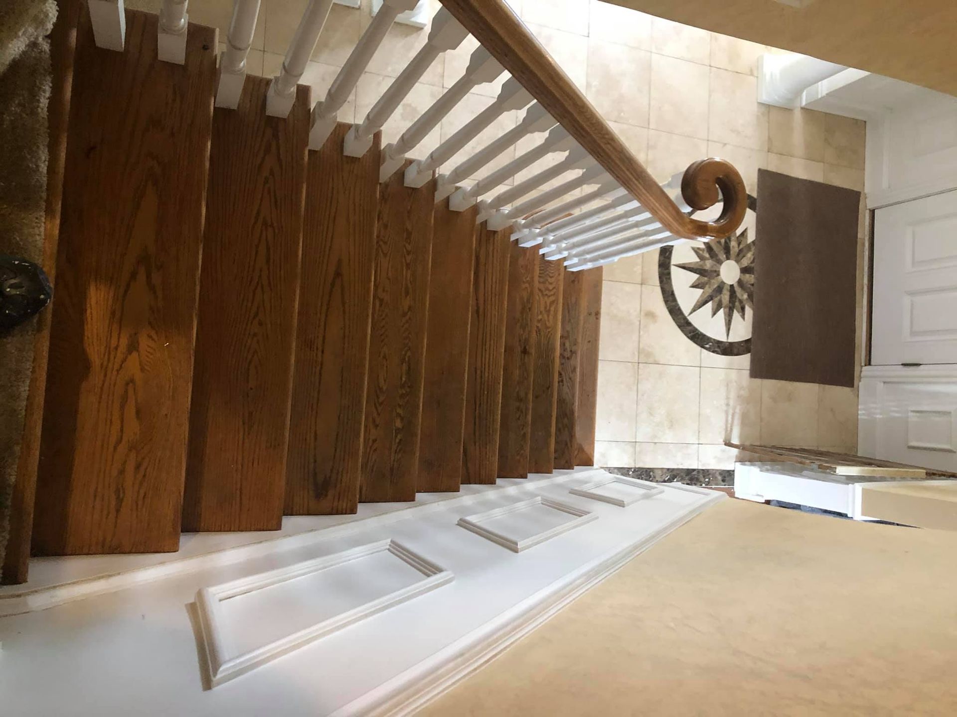 A staircase with wooden steps and white railings in a house.