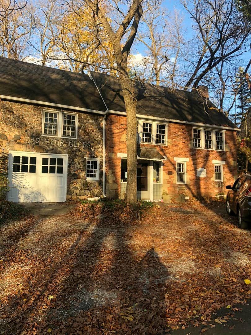 A brick house with a white garage door and a car parked in front of it.