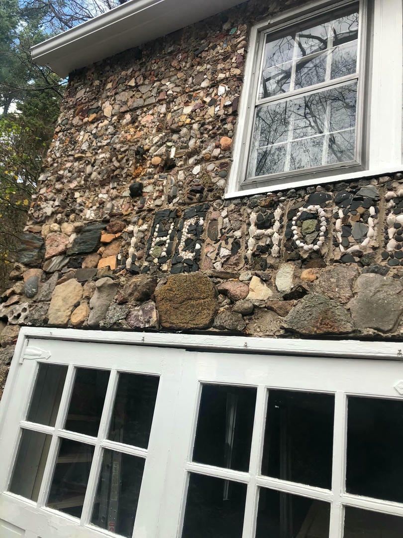 A stone wall with the word the house written on it.