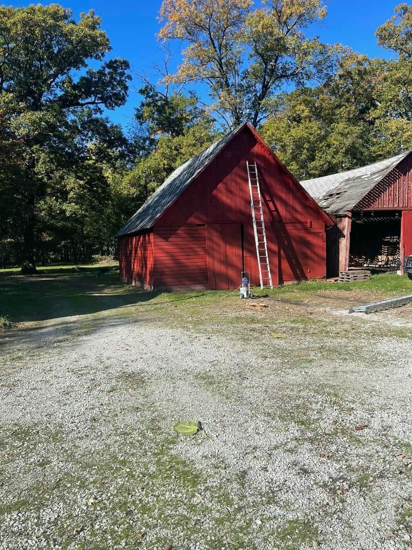 A red barn with a ladder on the side of it.