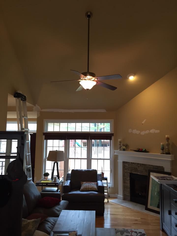 A living room with a fireplace and a ceiling fan