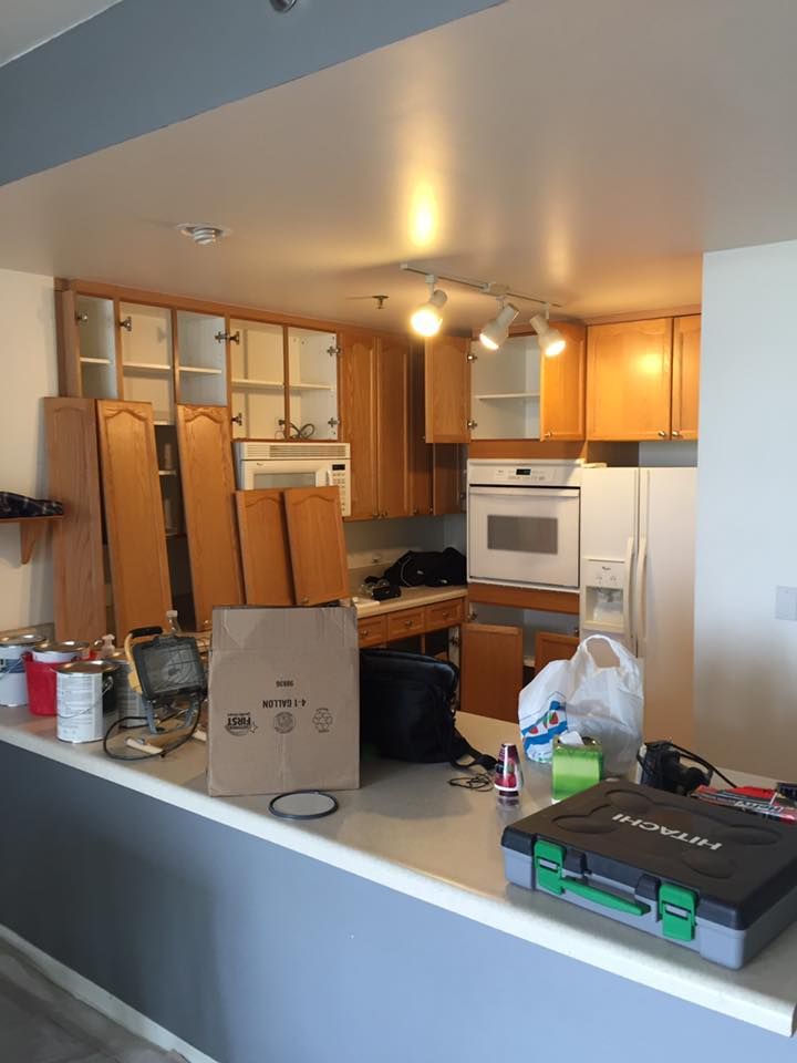 A Kitchen With Wooden Cabinets And A Green Toolbox On The Counter