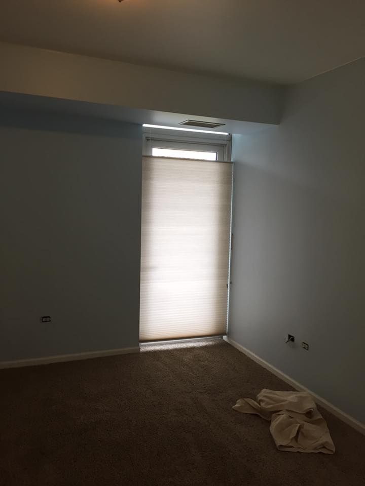 An Empty Room With A Window And Blinds On It