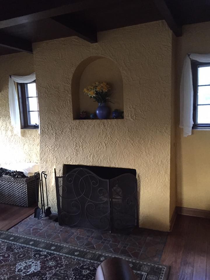 A Living Room With A Fireplace And A Window