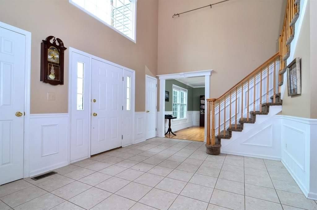 An Empty Hallway With Stairs And A Clock On The Wall