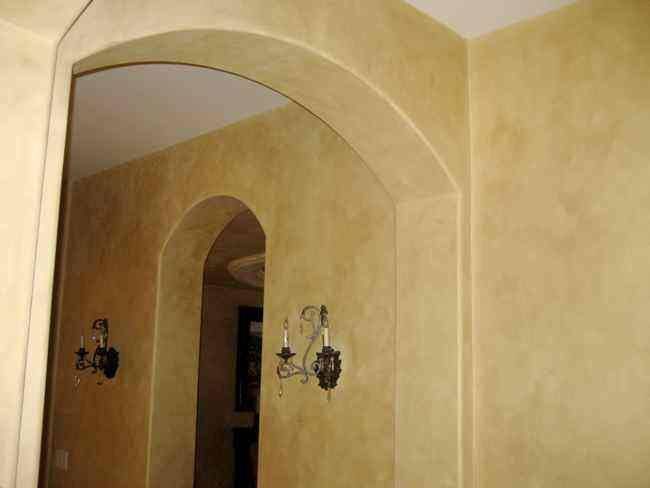 A Hallway With Arches And A Lamp On The Wall