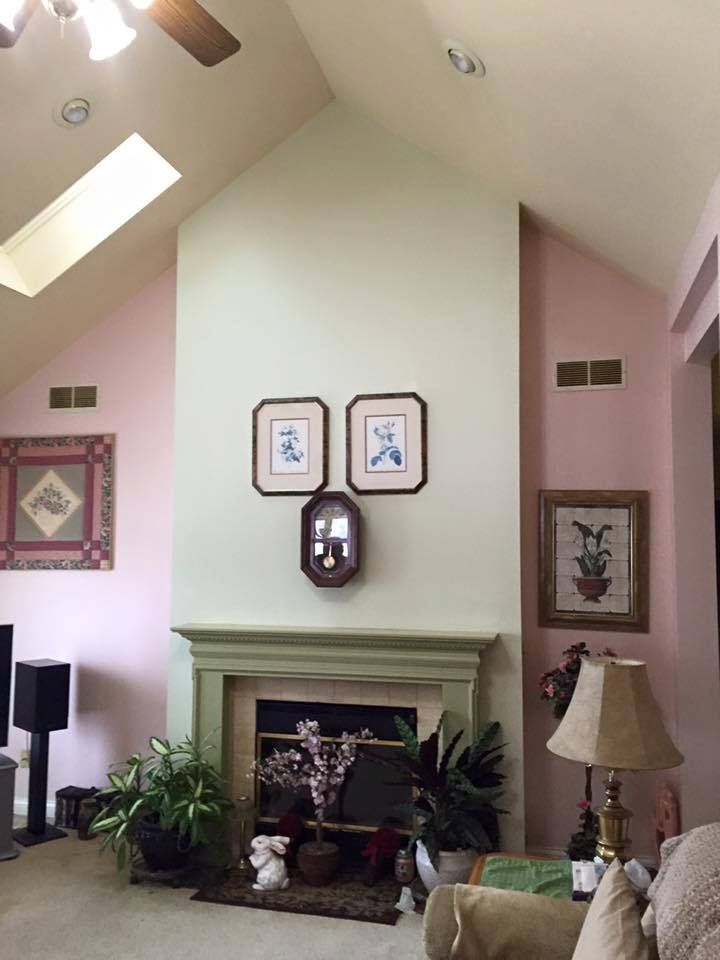 A living room with a fireplace and a ceiling fan