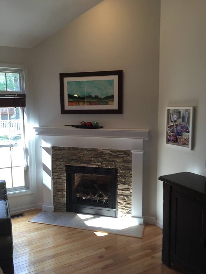 A Living Room With A Fireplace And A Picture On The Wall Above It