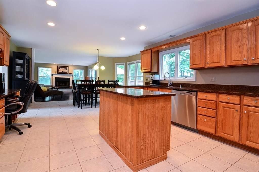 A Kitchen With Wooden Cabinets And Stainless Steel Appliances