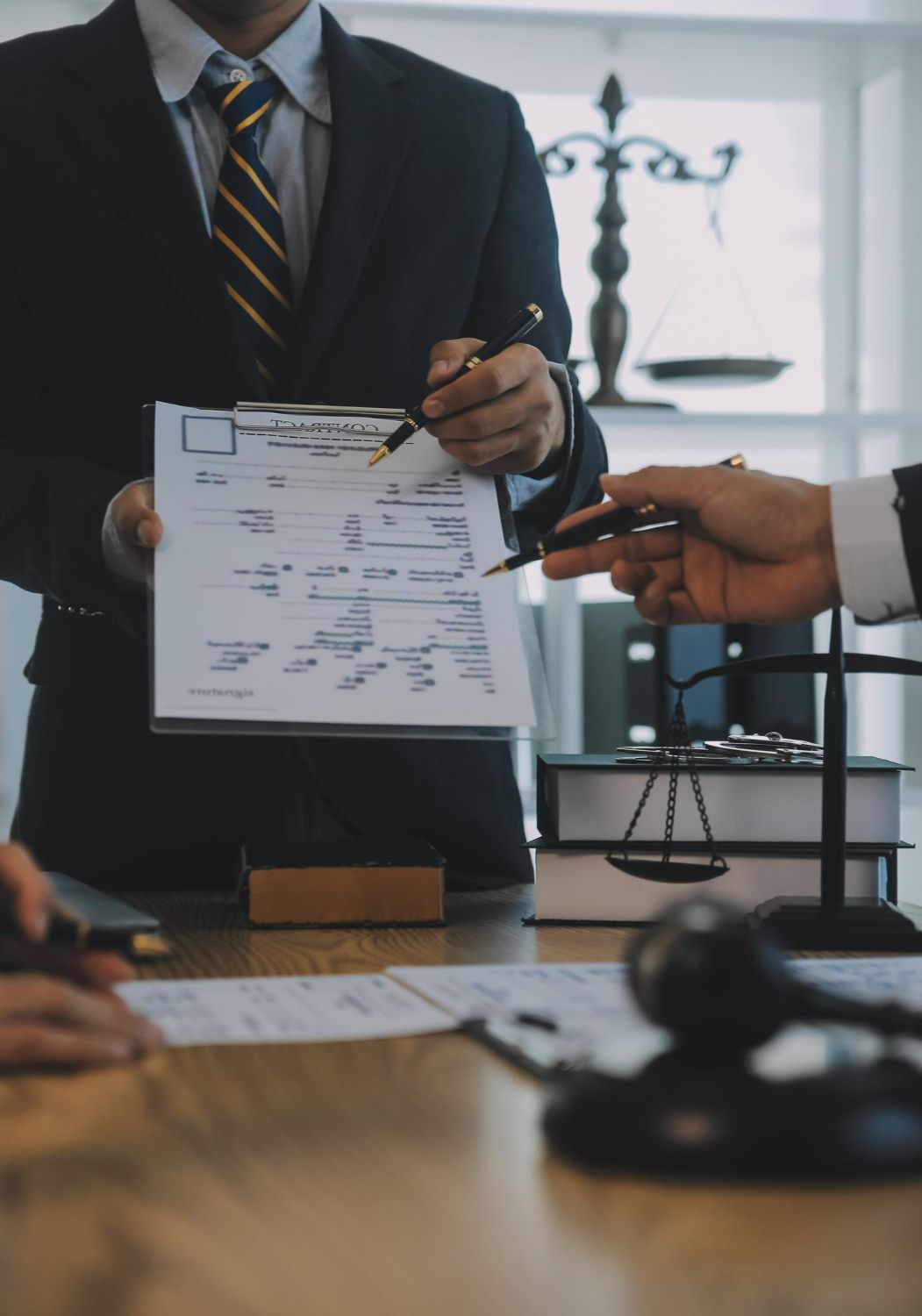Business meeting with hands reviewing documents and signing papers at a conference table
