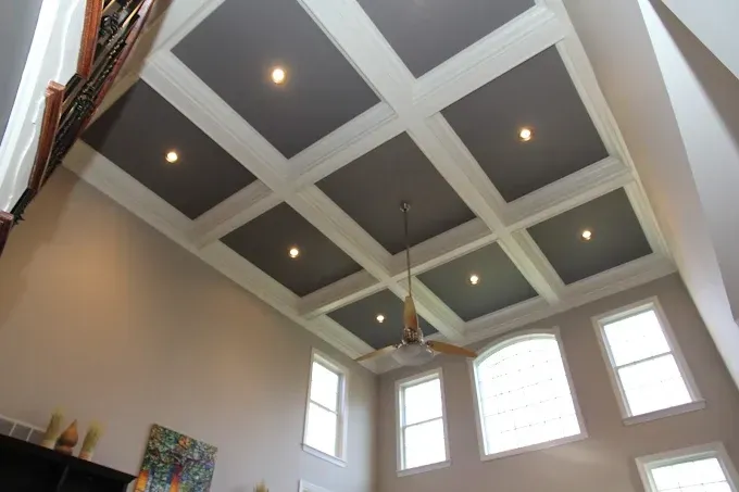High ceiling with a coffered design, gray panels, white trim, and recessed lights; a ceiling fan hangs below.