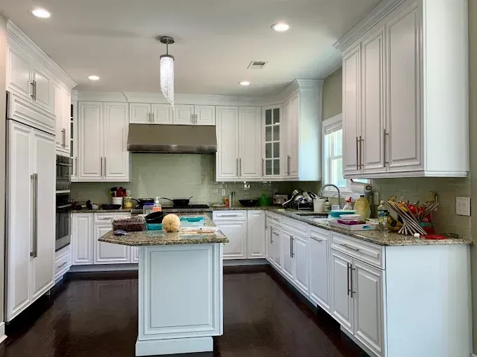 White kitchen with white cabinets, a center island, and stainless steel appliances.