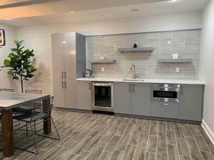 Modern gray kitchen with cabinets, sink, microwave, and a built-in wine cooler.