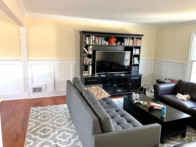 Living room with black entertainment center, grey sofa, and wood flooring.