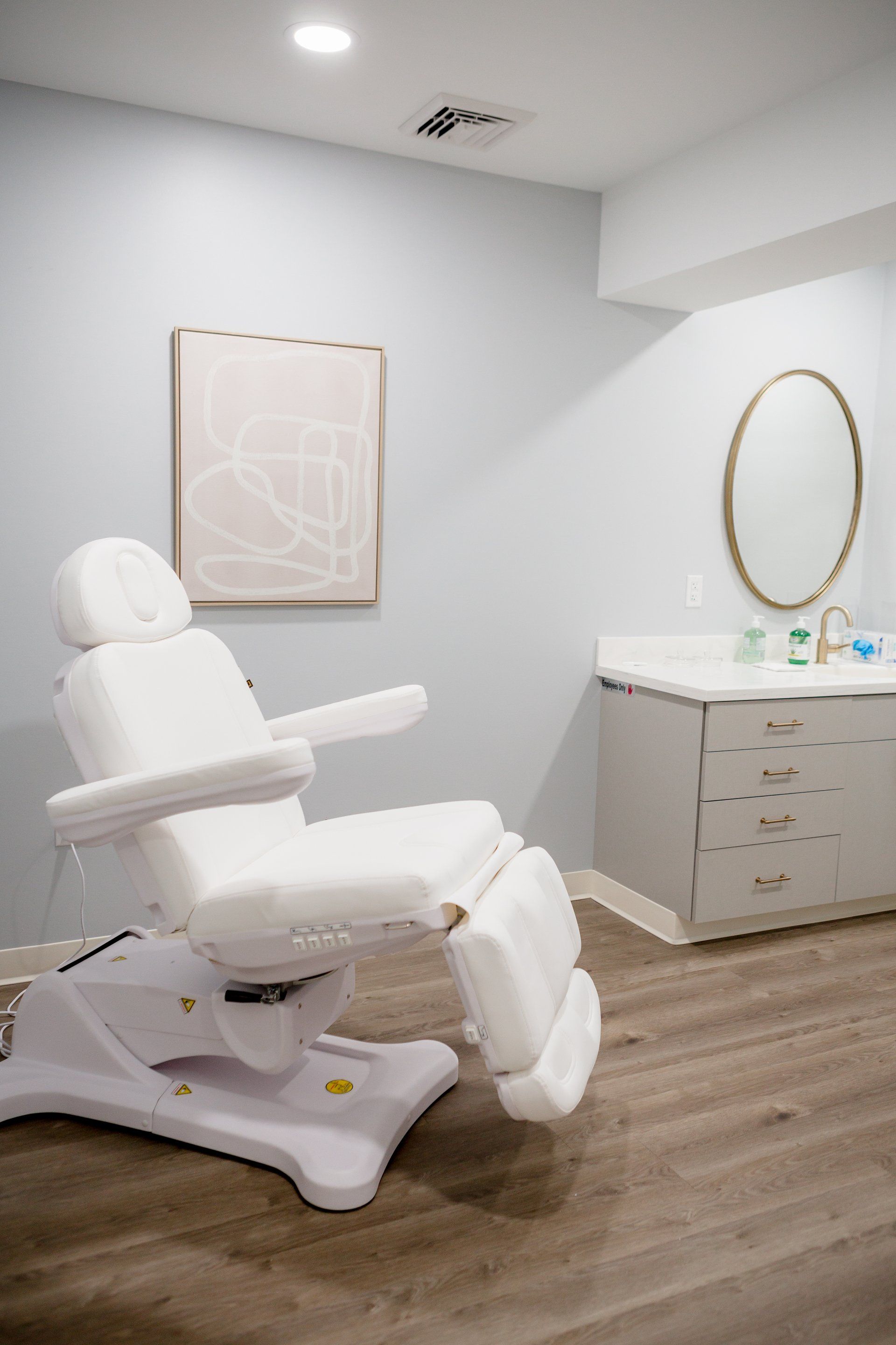 A white chair is sitting in a room next to a sink.