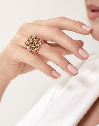 Una mujer lleva un anillo de oro en su mano izquierda.