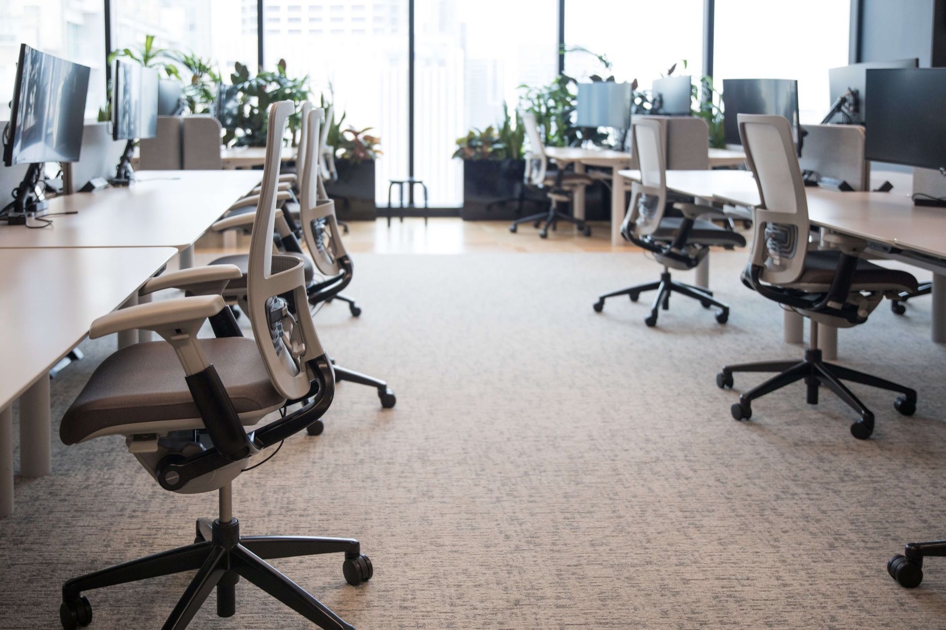A Modern Office Features a Dark Wood Cabinet, a Sleek Desk with A Computer, an Office Chair, and A Blank Wall Frame.
