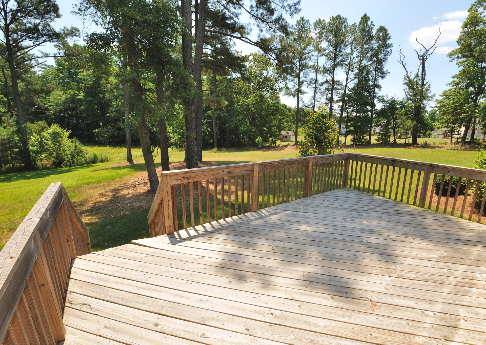A wooden deck with trees in the background