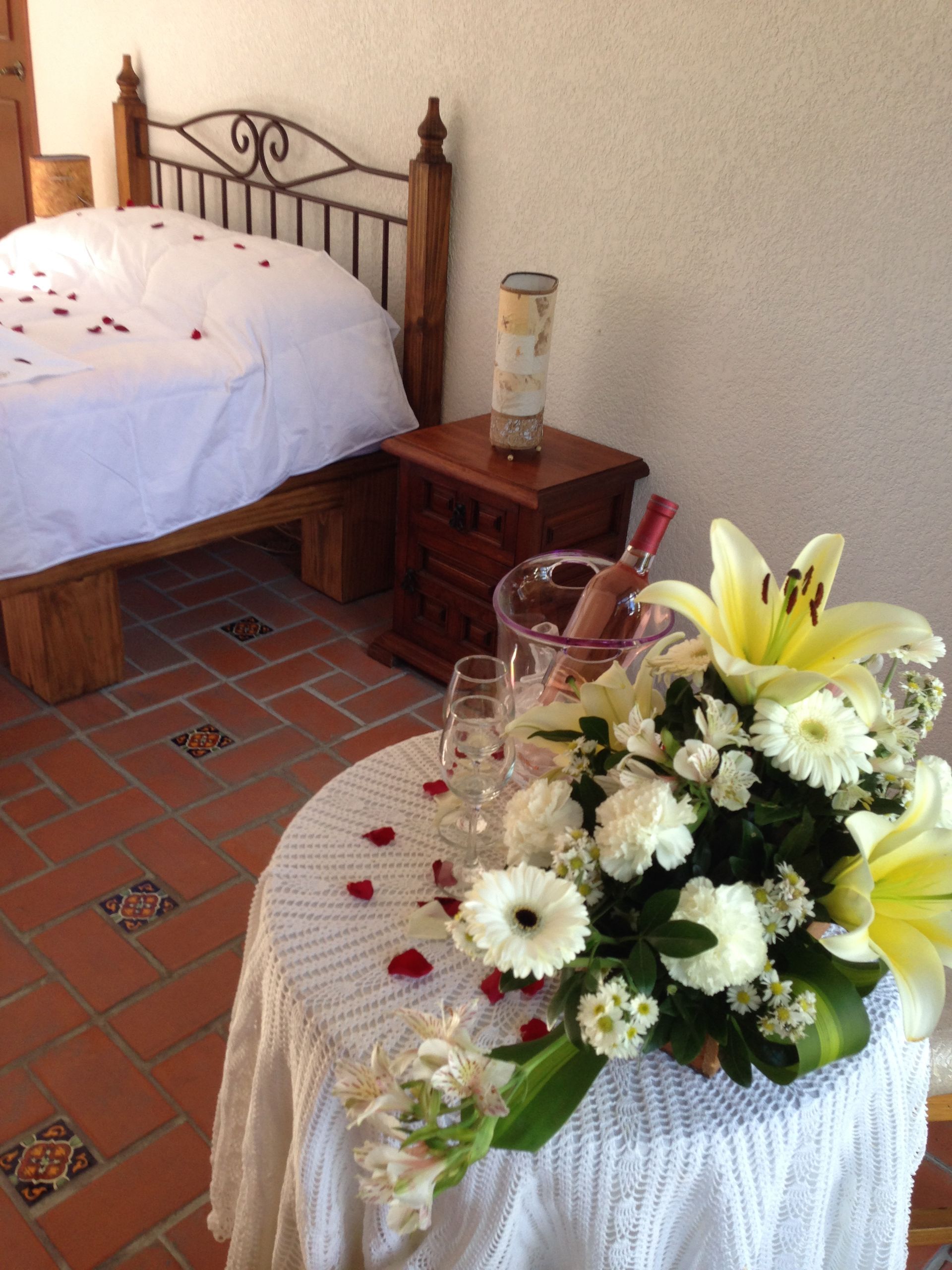 Una habitación con una cama y una mesa con flores.