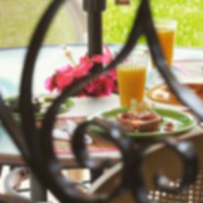 Una mesa con un plato de comida y un vaso de jugo de naranja.