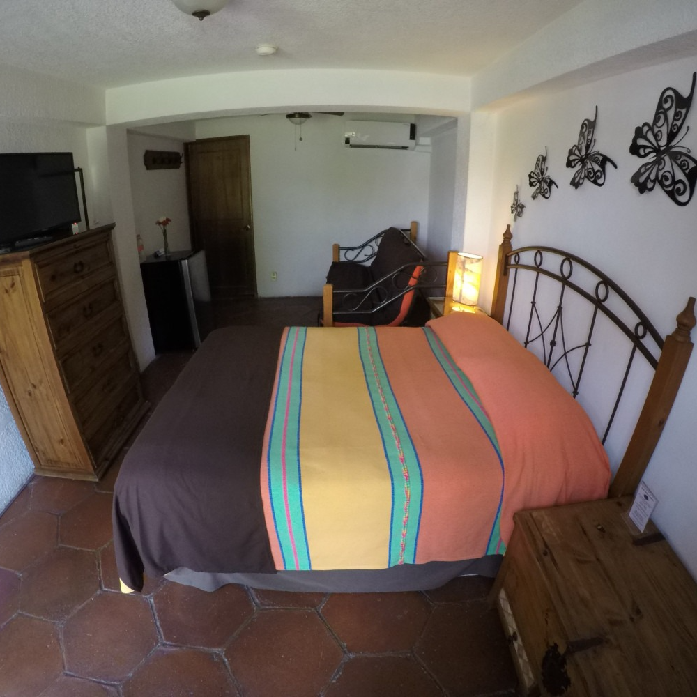 Un dormitorio con una cama grande y una cómoda.