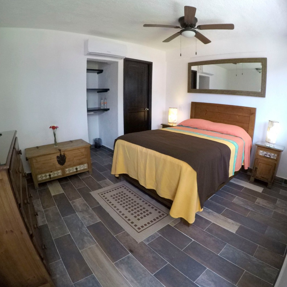 Un dormitorio con una cama grande y un ventilador de techo.