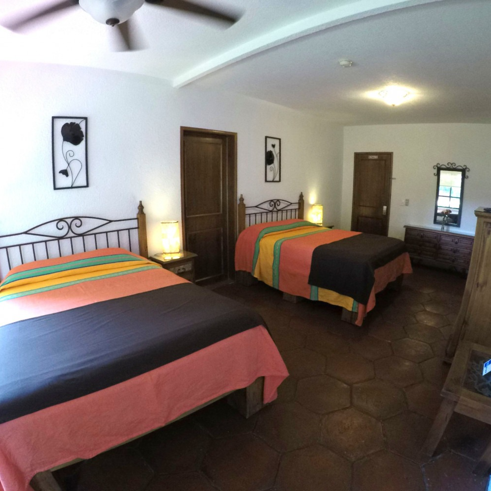 Un dormitorio con dos camas y un ventilador de techo.