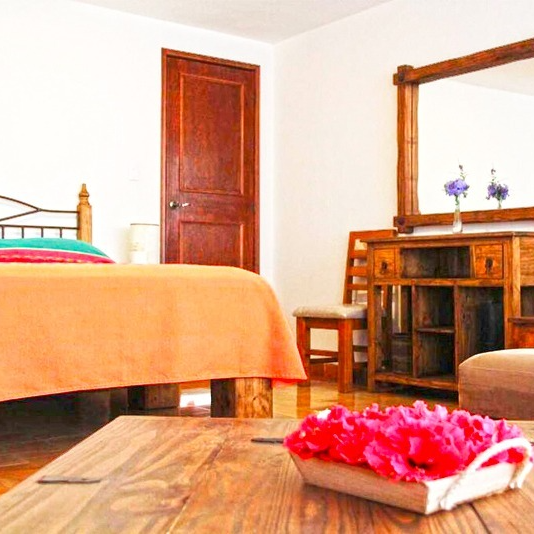 Un dormitorio con una cama, un escritorio y un espejo.